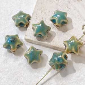 Detailed view of vintage star-shaped ceramic beads with blue-green reactive glaze finish