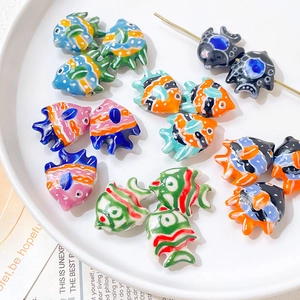 Dettaglio di perline di ceramica a forma di pesce dipinte a mano per gioielli fai da te
