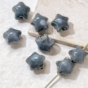 Macro view of vintage star-shaped ceramic beads with grey-blue crystalline glaze for DIY jewelry