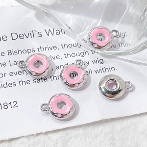 Detailed view of pink enamel donut charms for DIY handmade jewelry and craft projects