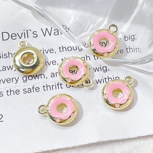 Detail of five pink enamel donut pendants with gold plating for DIY jewelry making