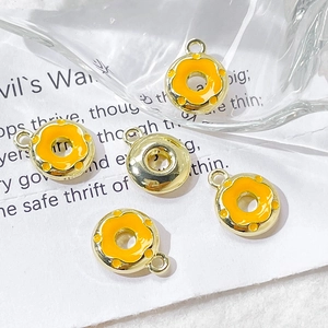Detail of five colorful alloy donut pendants for DIY jewelry making on white background