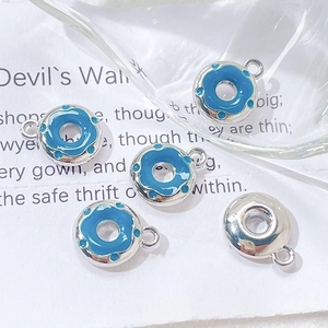 Detail of five blue enamel donut charms with silver finish for DIY jewelry making