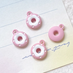Makroaufnahme von rosa Emaille Donut Anhängern mit Details für DIY-Schmuckherstellung
