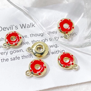 Detailed macro view of red enamel donut charms with gold metal rings for DIY jewelry making