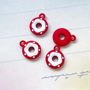 Makroansicht von 4 roten Donut-Anhängern mit Matt-Textur und weißen Streuseln für DIY Schmuck