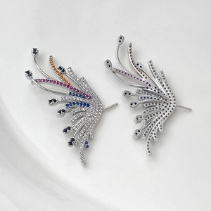 Detailed macro view of gold-plated wing charms with multicolor zircon stones and honeycomb back