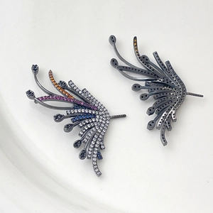 Macro detail of wing earrings featuring colorful cubic zirconia on dark plated metal base