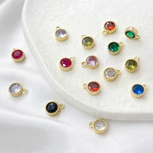 Detalle de dijes redondos de circón bañados en oro de 14k para creación de joyas