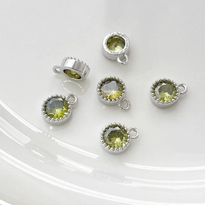 Detalle de colgantes redondos de circón verde oliva con borde milgrain plateado para joyas