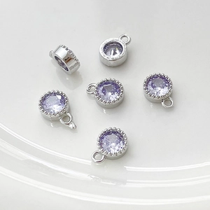 Detalle macro de colgantes redondos de circón lavanda bañados en oro 14k para joyería