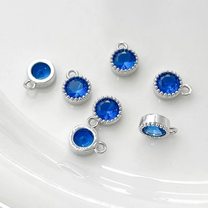 Vista macro de seis colgantes de circón azul con bordes milgrain para joyería artesanal