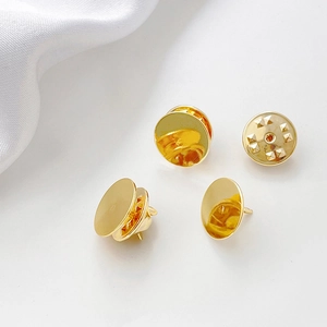 Golden plated pearl pin backs and tie tacks fasteners on white silk background
