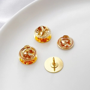 Polished gold plated pearl pin back and butterfly clutch fastener set on white plate