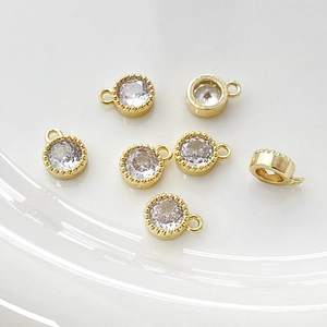 Vista macro de dijes redondos de circón bañados en oro de 14k con bordes de cuentas para DIY