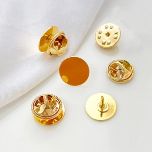 Macro shot of gold-plated pearl brooch clutch and flat head pins for DIY jewelry making
