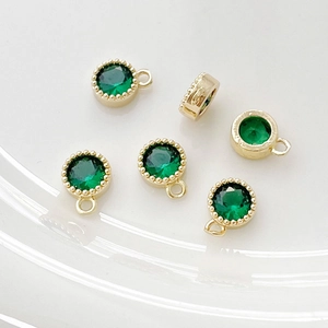 Primer plano de colgantes redondos bañados en oro 14k con circón verde para joyería