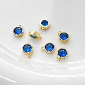 Detalle de dijes de cobre chapados en oro de 14k con circón azul para crear joyas DIY