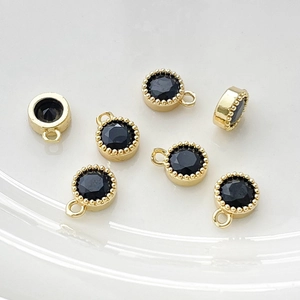 Vista macro de colgantes de cobre bañados en oro de 14k con circonitas negras facetadas