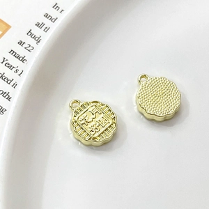 Macro detail of gold mooncake charms showing delicate patterns and circular hanging loops