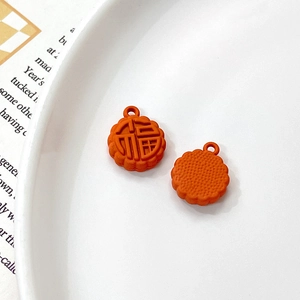 Detail of orange rabbit mooncake pendant with Fu character on white ceramic tray