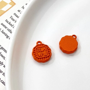 Detailed close-up of orange mooncake charms with floral patterns and hanging loops