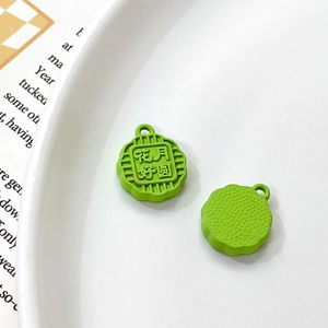 Detailed macro view of grass green mooncake pendant with floral pattern and circular loop
