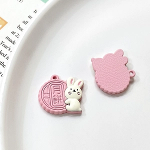 Macro detail of pink rabbit mooncake pendants showing front and textured back surface