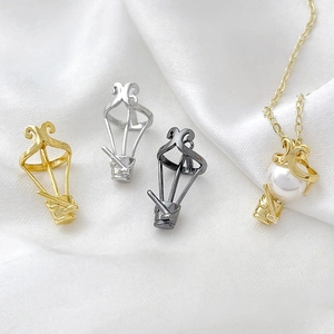 Hot air balloon jewelry pendants in gold, silver, and black finish on white silk fabric