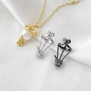 Three-color metal balloon pendants with pearl inlay on elegant white silk background