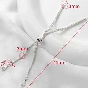 Detail of adjustable 14k gold box chain with cubic zirconia teardrop charm and slider bead