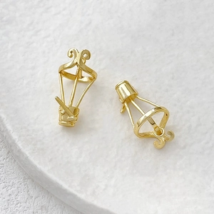 Macro shot of gold-plated hot air balloon style jewelry DIY charms on a white stone base