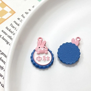 Detailed macro view showing the front and back of rabbit mooncake charm with Mid-Autumn text
