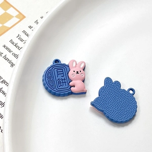 Detail of pink bunny and mooncake resin charms with hanging holes for DIY jewelry