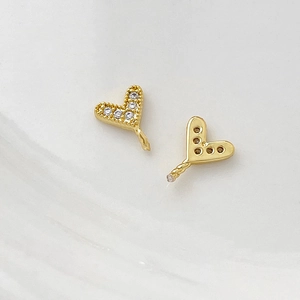 Detailed macro view of gold-plated heart-shaped pendants with micro-set zircon stones