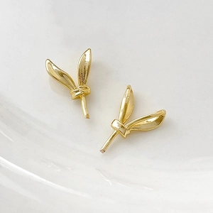 Detailed close-up of gold-plated rabbit ear earstuds with high-gloss metallic finish