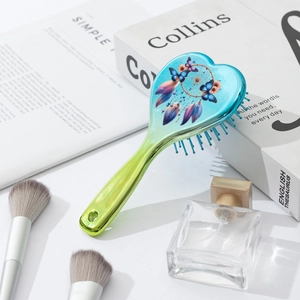 Heart-shaped air cushion hairbrush with butterfly dreamcatcher design and teal finish