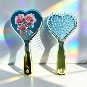 Detailed view of heart hairbrush with floral pattern and metallic plating finish