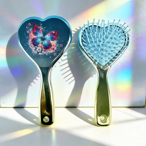 Détail de la brosse à cheveux en forme de cœur avec imprimé papillon et picots de massage