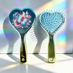 Détail de brosse à cheveux en cœur avec motif papillon et picots de massage doux