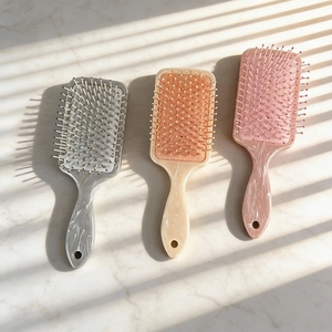 Marble pattern air cushion hairbrushes in grey, beige and pink with massage bristles