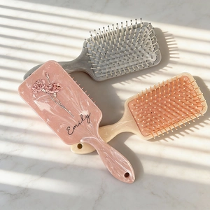 Marble textured floral paddle brushes in pink, grey and cream with personalized engraving