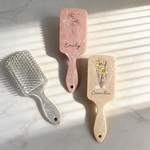 Detail of marble pattern hair brush with personalized floral print and customized names