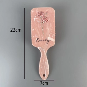 Detail view of 22cm x 7cm marble floral hairbrush with pink flower patterns