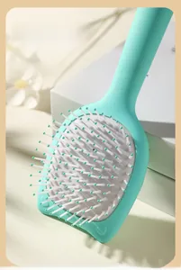 Detail of mint green air cushion hairbrush with white massage bristles and soft base