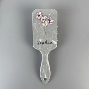 Detail of marble texture hairbrush with floral pattern and personalized Sophia name