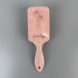 Detail of pink marble hair brush featuring floral pattern and customized Emily name