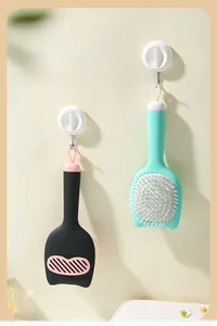 Detail of cute cat-shaped hairbrush showing standing base and wall-mounted storage hook