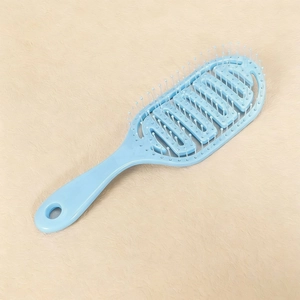 Macro detail of a light blue hollow vented hairbrush with massage bead tips and wide teeth