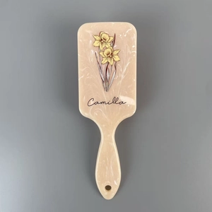 Detail of marble pattern hairbrush with yellow flower print and Camilla text design